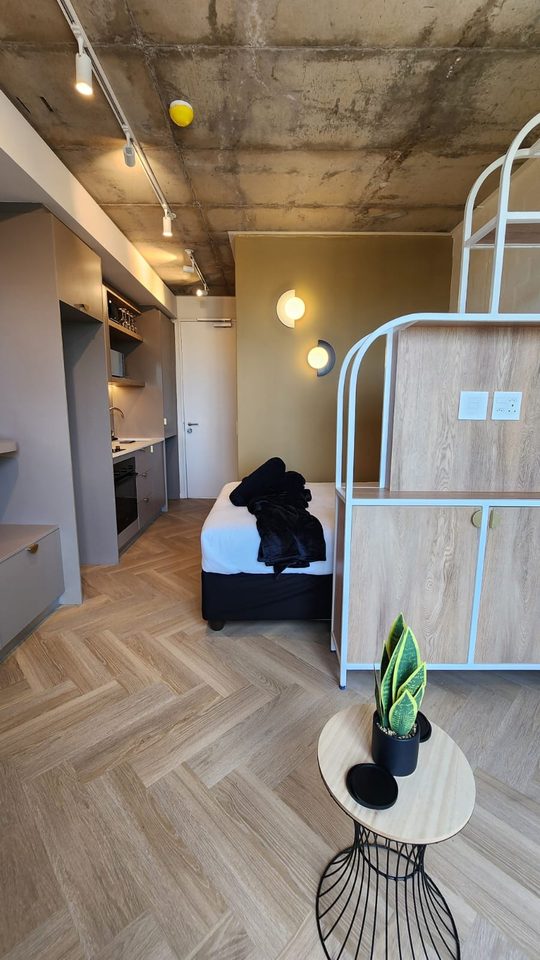 Bed, open shelving and table in the studio