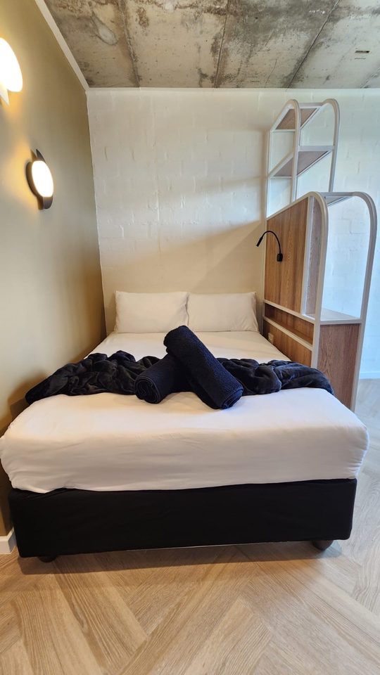 Bed against the wood-panelled wall