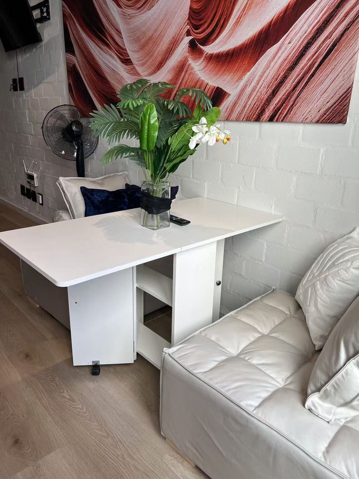 Sofa corner and fold-out table under the orange canyon artwork
